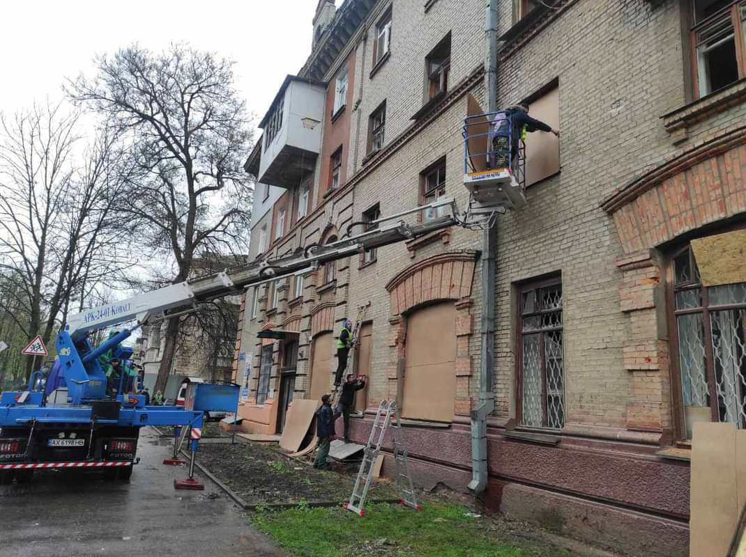 Заколачивают выбитые обстрелом окна в Харькове