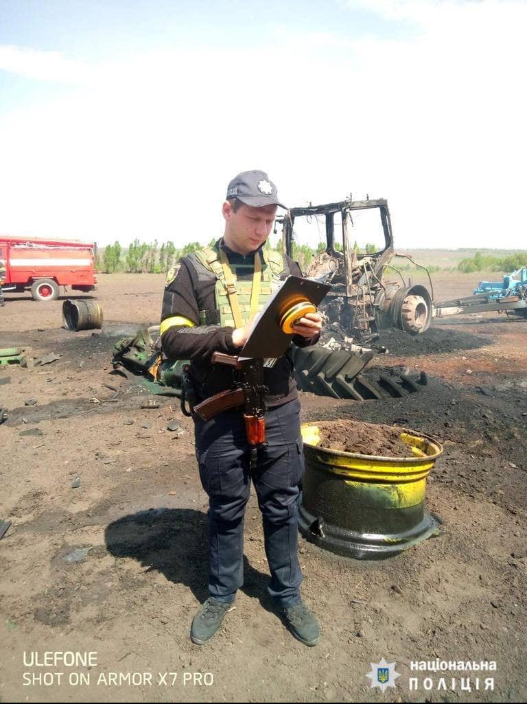 Полиция проводит осмотр места происшествия в поле, где от обстрела загорелся трактор