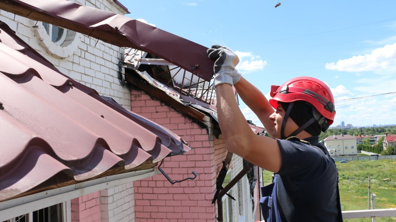 Рятувальник розбирає покрівлю будівлі на Північній Салтівці
