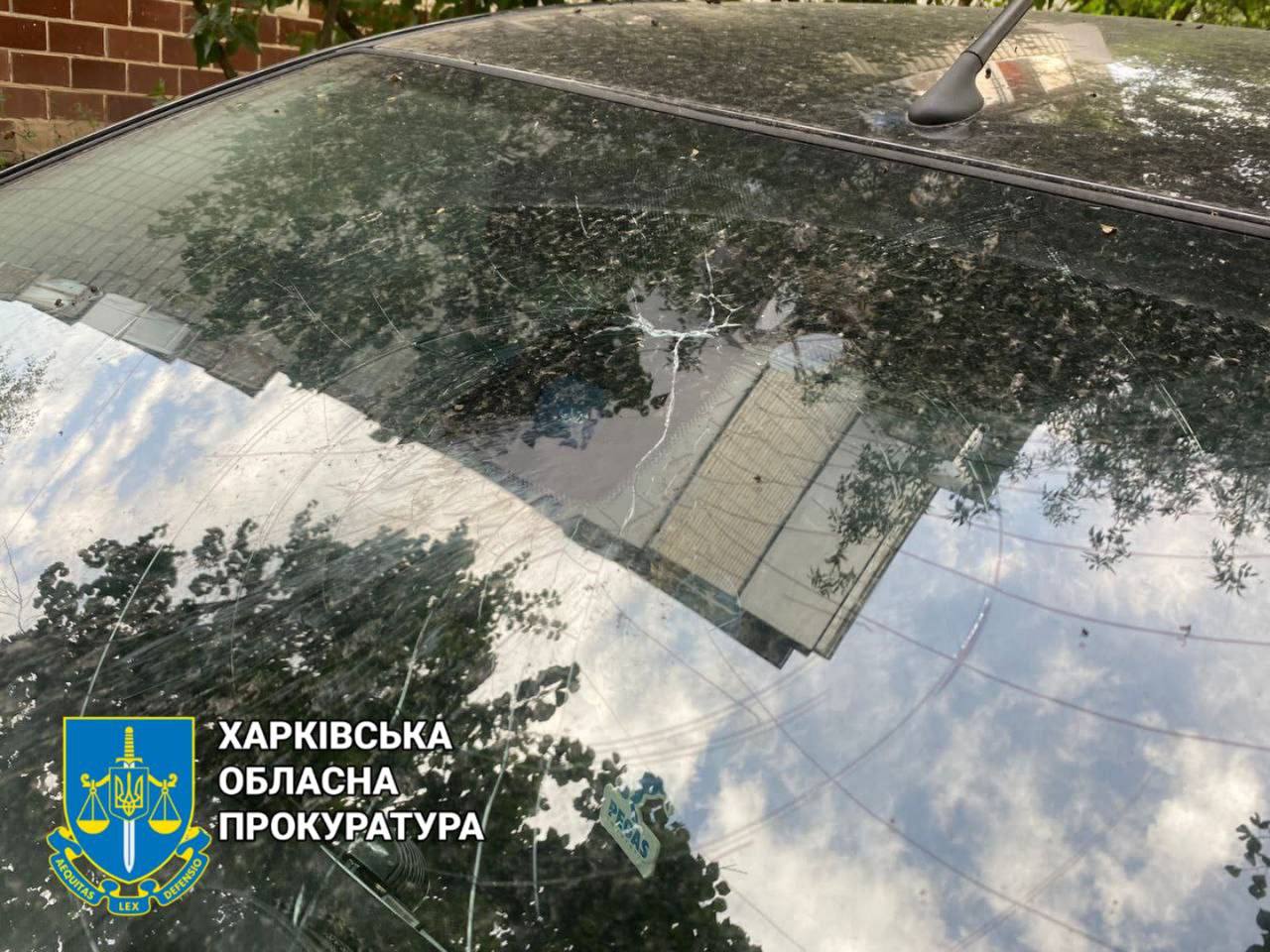 Поврежденный обстрелом автомобиль во дворе в Харькове