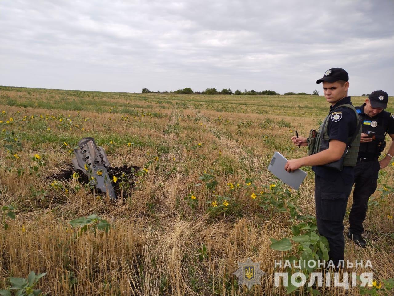 Полицейский фиксирует ракетный удар в поле в Харьковской области 