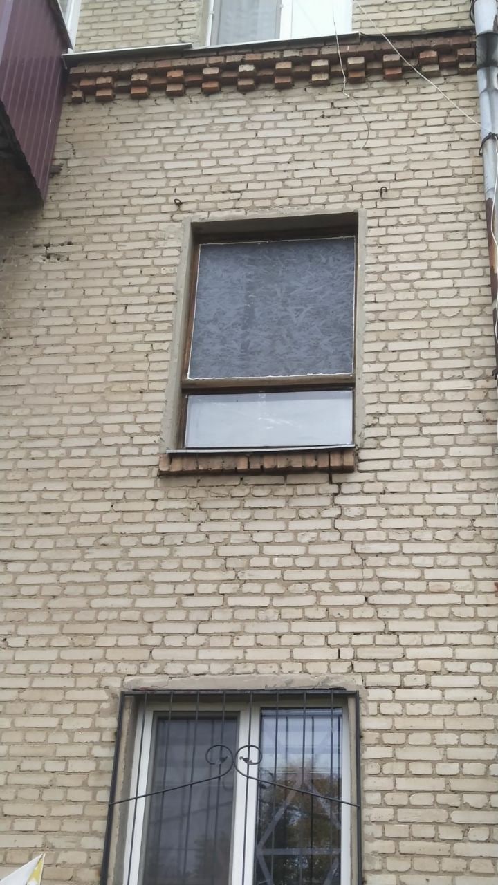 Закрытое ДСП окно, выбитое взрывом в Харькове