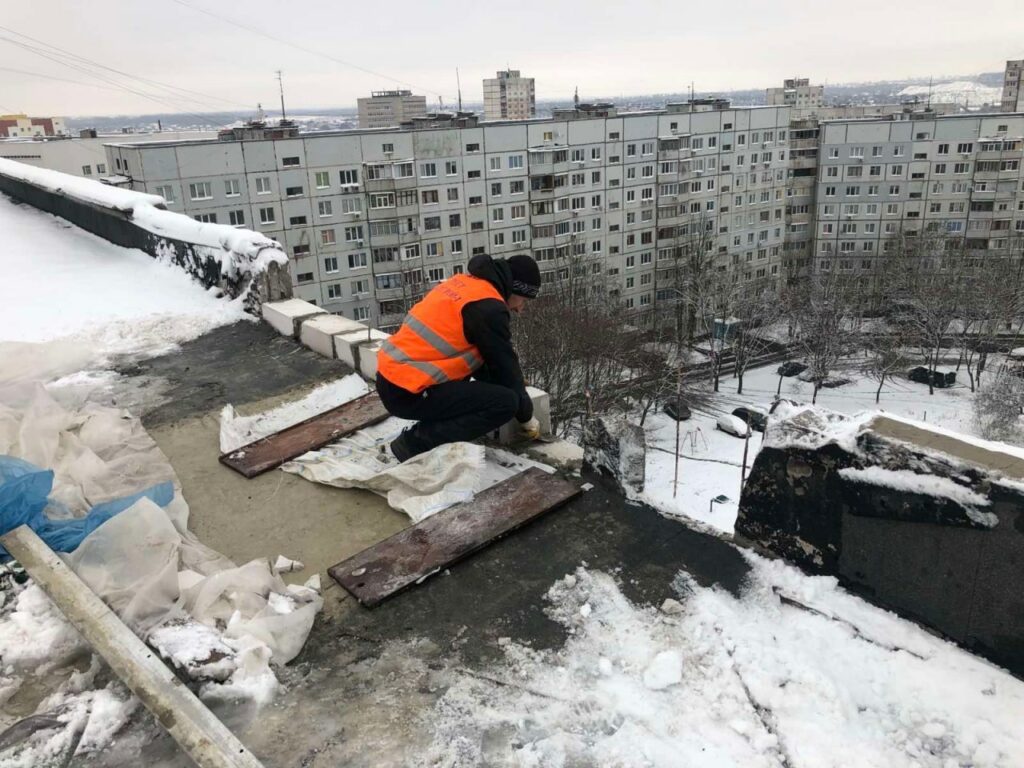 В Харькове строители восстанавливают заснеженные крыши после обстрелов (фото)
