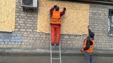 Окна, разбитые взрывной волной, закрывают коммунальщики в Харькове